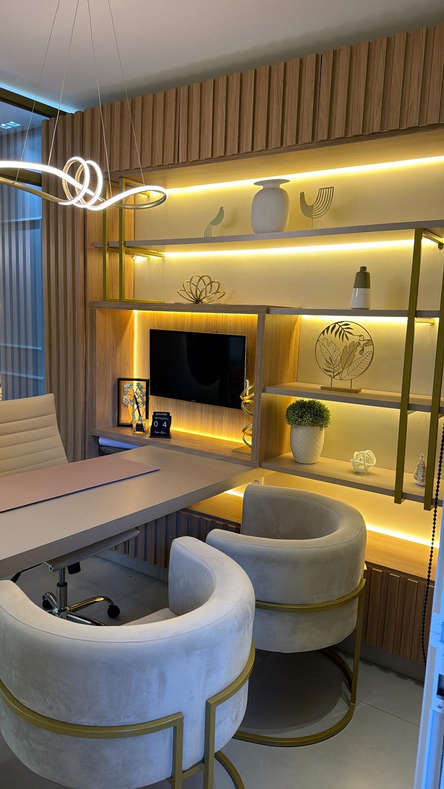 Sala de conversa com estante iluminada e poltronas bege